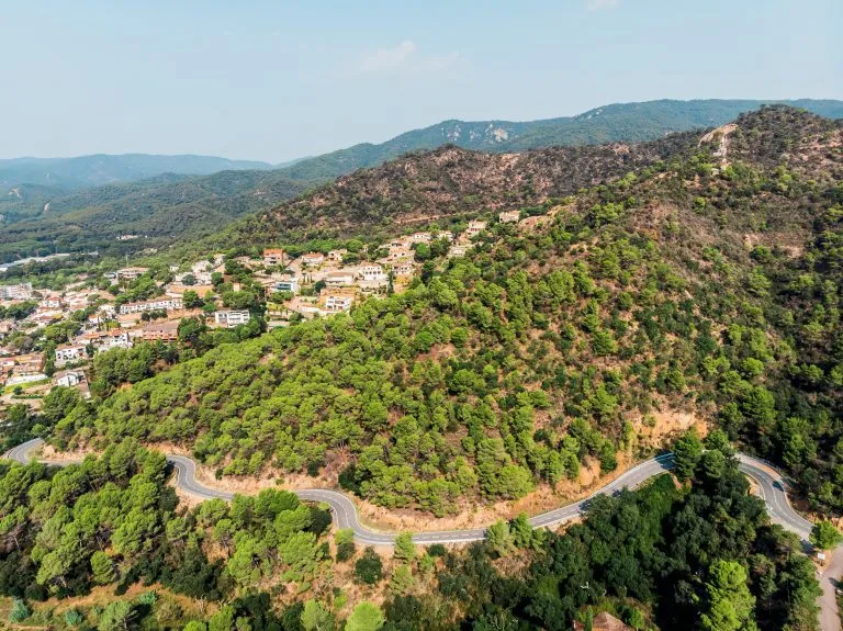 Uitzicht vanuit een drone op een bergweg in de stad Tossa de Mar. Drone-opname van een auto die over een bergweg rijdt. De badplaats Tossa de Mar bij de Middellandse Zee.
